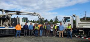 Public Works Staff in front of hydro vac truck and dump truck